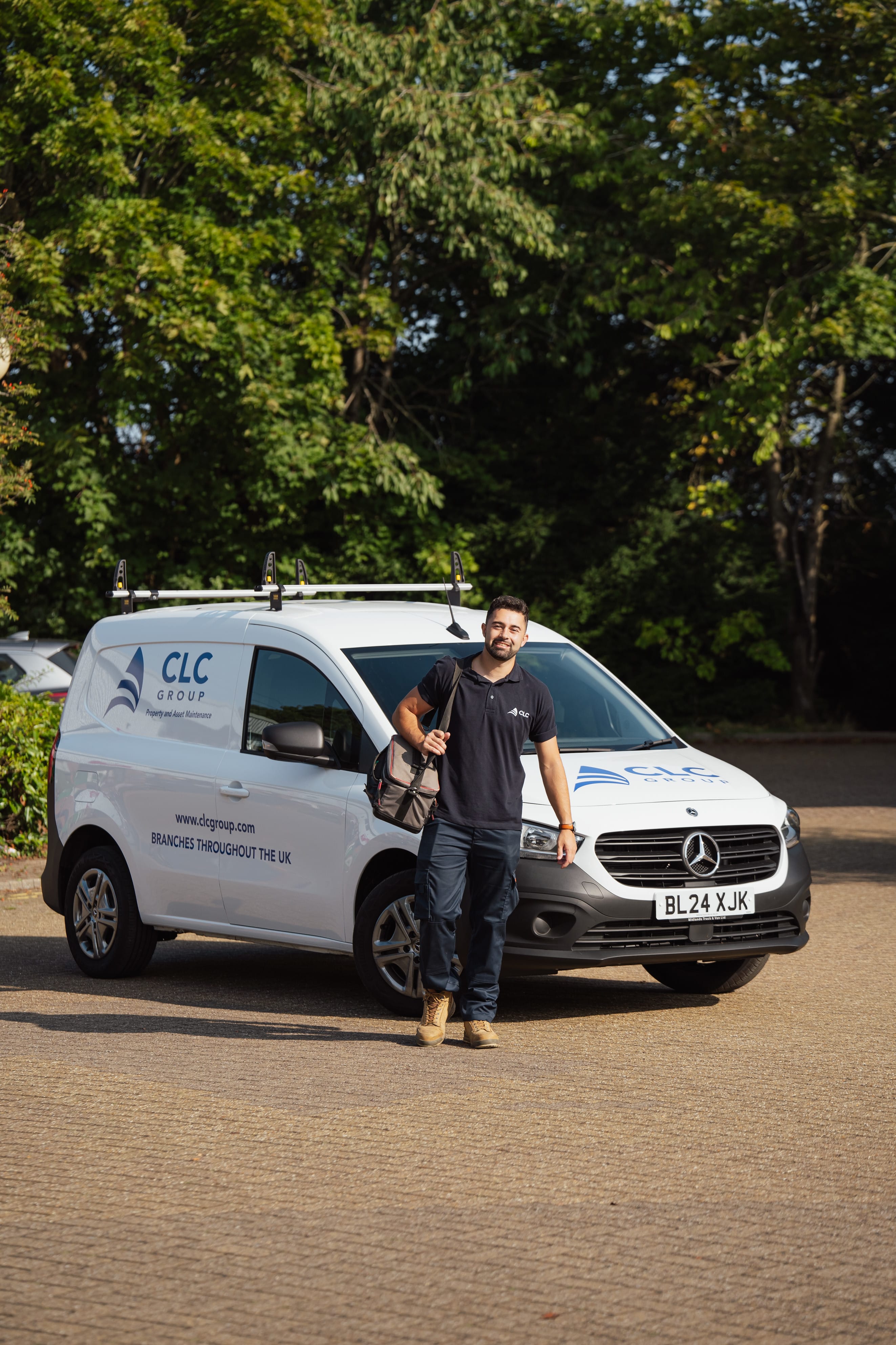 CLC subcontractor standing in front of a service van with a toolkit